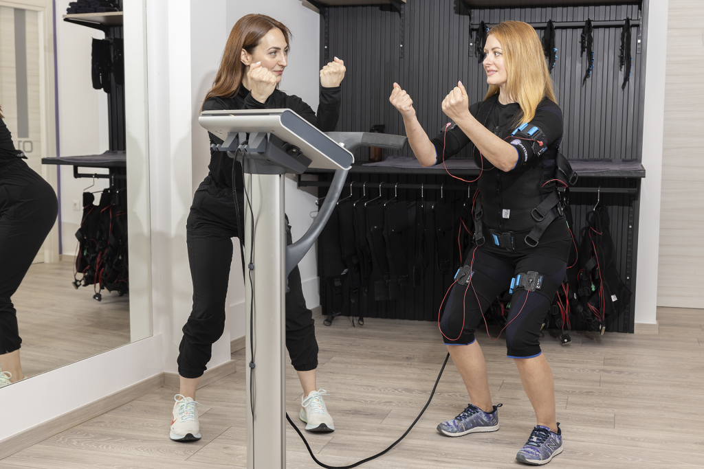 EMS trainer ρυθμίζει ένταση σε Miha Bodytec εξοπλισμό κατά την προπόνηση στα 20 Minutes Fitness